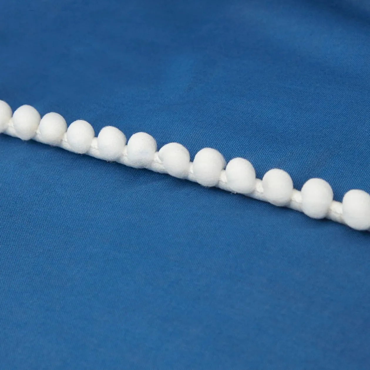 Parure de lit 2 places bleue finition pompons blancs